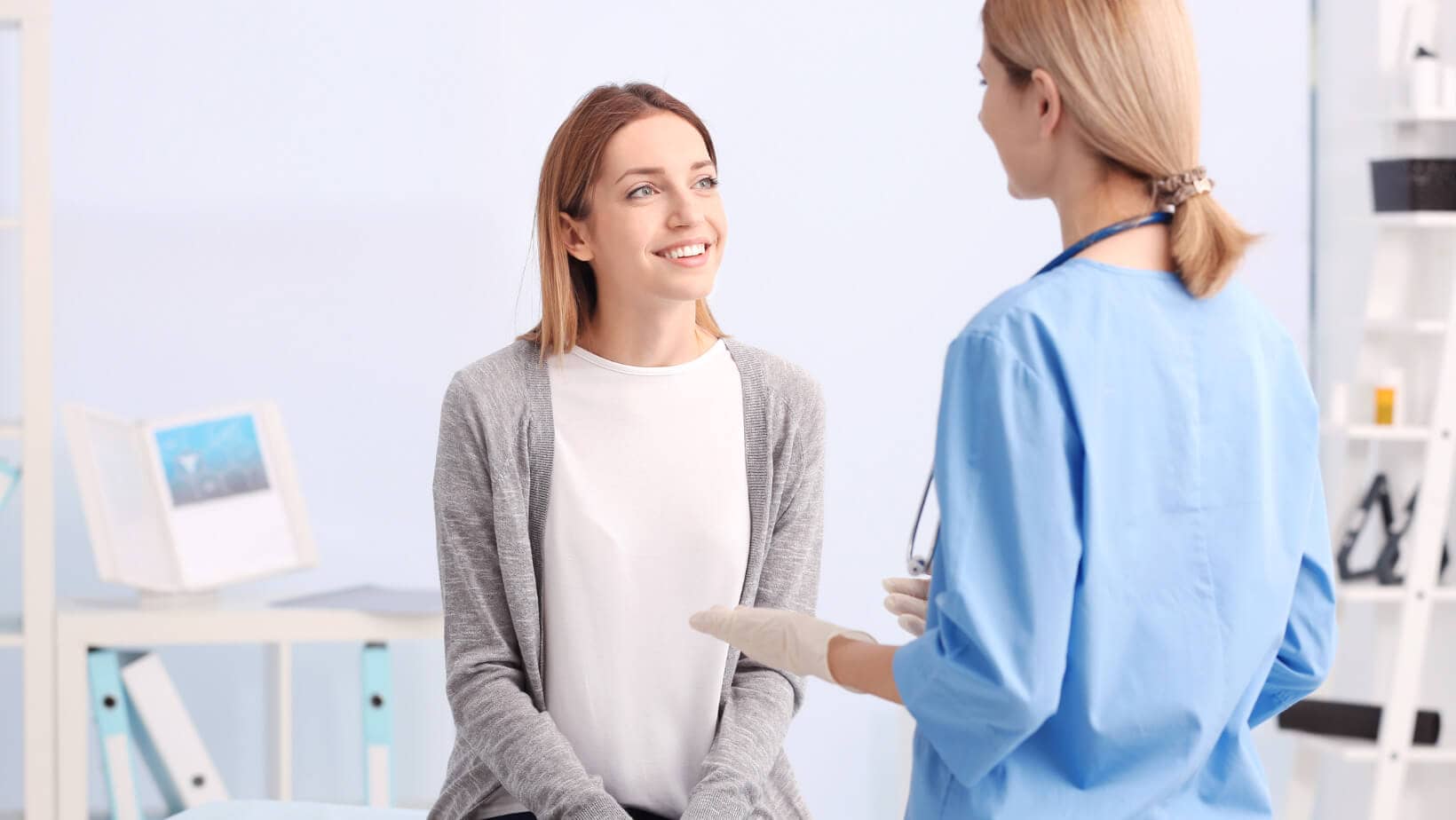 Vaginal Infection blog header image of woman sitting in a doctors office facing a woman in doctor or nurse coat