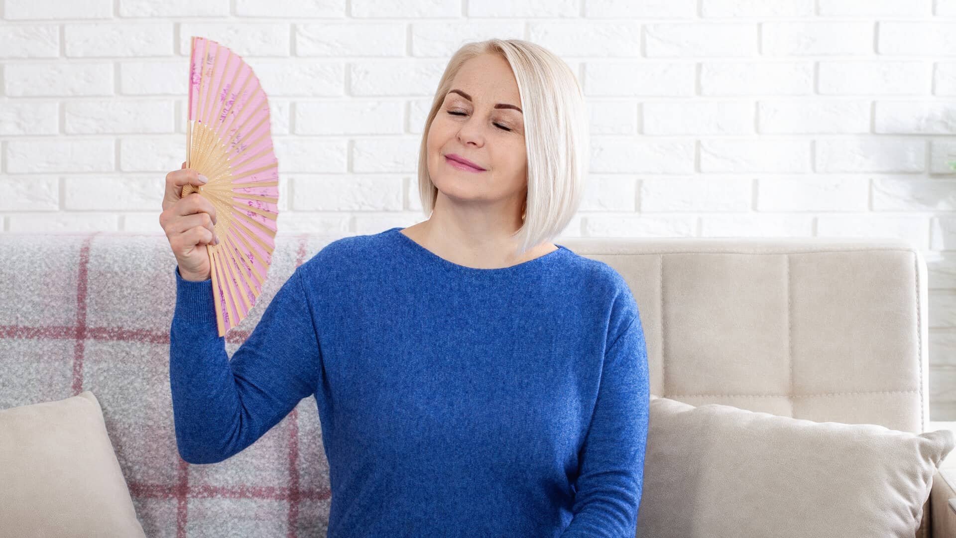 woman experiences hot flashes fanning herself